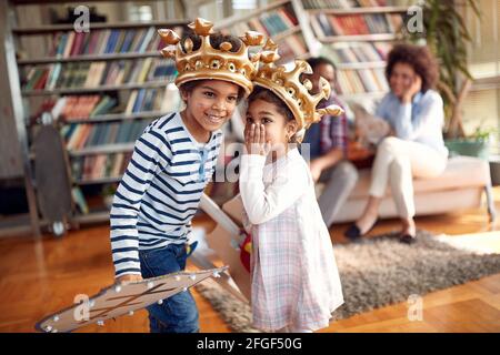 Die Kinder flüstern ein paar Geheimnisse, während sie zu Hause in familiärer Atmosphäre spielen. Familie, zusammen, Liebe, Spielzeit Stockfoto