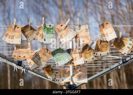 100 und 50 Euro Banknoten trocknen. Gewaschene Euro-Papierrechnungen. Euro an einer Schnur trocknend.Geldwäsche Stockfoto