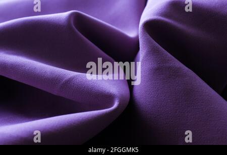 Nahaufnahme von violettem Stoff oder Tuch in violetter Farbe. Stoff Textur von lila Hintergrund. Zerknittert lila Stoff Stockfoto