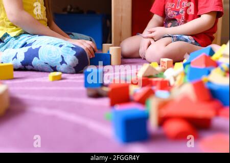 Kinder, Geschwister, Junge und Mädchen spielen zu Hause mit Spielzeug, hölzernen Bausteinen, während der Quarantäne-Selbstisolation covid-19 Corona-Virus Stockfoto