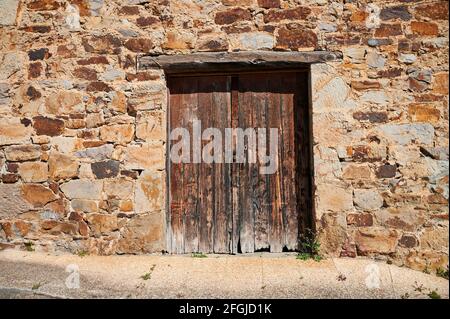 Alte Holztür in die Steinwand Stockfoto