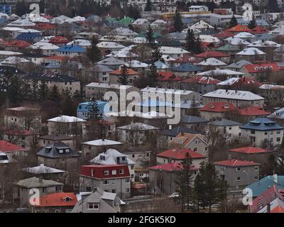 Schöne Luftaufnahme des Wohngebietes in Reykjavík, der Hauptstadt Islands, mit Gebäuden, bunten Dächern und Bäumen dazwischen am bewölkten Tag. Stockfoto