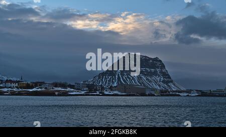 Blick auf das kleine Dorf Grundarfjörður an der nördlichen Atlantikküste der Halbinsel Snæfellsnes, Island mit Kirche und Gebäuden mit Berg. Stockfoto