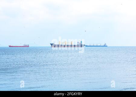 Frachtschiffe warten auf dem Meer, um einen Kanal zu passieren Oder strait Stockfoto