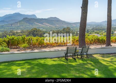 Blick mit zwei leeren Stühlen über die Weinberge von Franschhoek, Südafrika Stockfoto