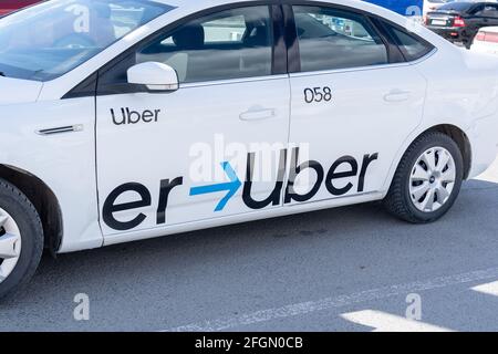 Tjumen, Russland-17. april 2021: Das Taxi mit dem Uber-Logo ist auf einem weißen Auto zu sehen Stockfoto