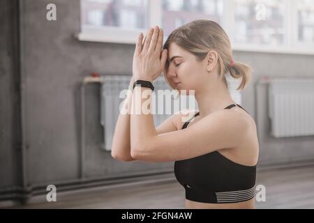 Nahaufnahme einer jungen Frau, die eine Namaste-Geste nach sich führt Yoga im Fitnessstudio Stockfoto