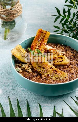 Haferflocken aus Schokolade mit karamellisierter Banane und Nüssen Stockfoto