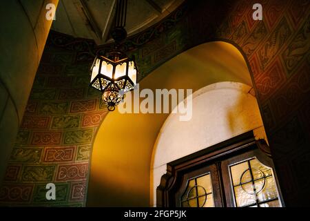 Antike Wandleuchte auf einer Wendeltreppe im Schloss Neuschwanstein. Stockfoto