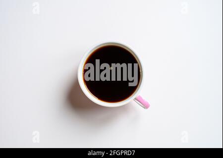 tasse mit schwarzem oder dunkelbraunem reichem Chaga-Tee, gebraut aus Birkenbaum-Chaga-Pilz isoliert auf weißem Hintergrund. Konzept der alternativen natürlichen Sanitäter Stockfoto