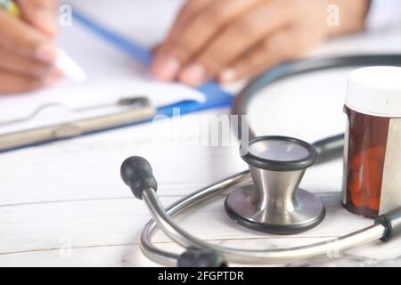 Stethoskop, weißes Blatt Papier und Pillen auf Klinik-Tisch . Stockfoto