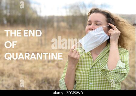 Ende der Isolation und Quarantäne Corona Virus covid-19 Konzept. Eine junge Frau entfernt eine medizinische Maske aus ihrem Gesicht und atmen frische Luft in der Natur Stockfoto