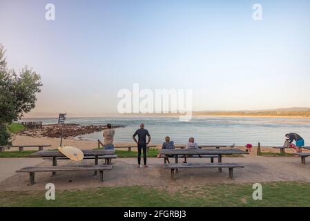 Junge und alte Boardrider beobachten die Brandung in der Bar Beach In Merimbula an der Südküste von New South Wales Australien am frühen Morgen Stockfoto