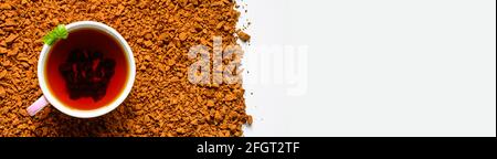 Chaga-Pilztee. Eine Tasse gebrühter Tee aus Birkenpilz-Chaga auf einem Haufen kleiner gebrochener Stücke isoliert auf weißem Hintergrund. Banner. Platz für Text Stockfoto