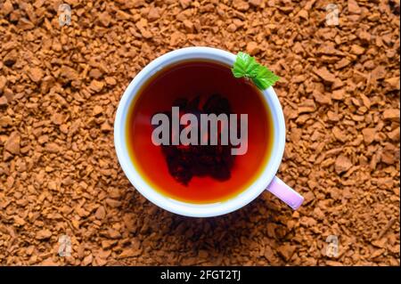 Chaga-Pilztee. Eine Tasse gebrühter Tee aus Birkenpilz-Chaga auf einem Haufen kleiner Bruchstücke Stockfoto