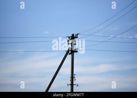 Alte Säule mit Drähten am blauen Himmel bei Sonnenschein Tag Stockfoto