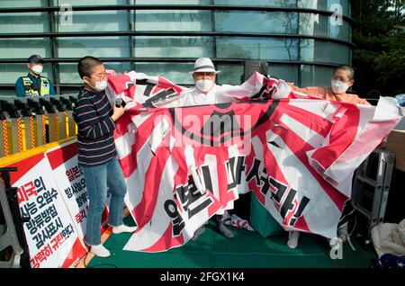 Seoul, Südkorea. 24. Apr 2021: Protest gegen Japan zur Freisetzung von mit radioaktivem Material kontaminiertem Wasser aus Fukushima, 24. Apr 2021: Südkoreanische Demonstranten zerreißen eine japanische aufgehende Sonnenflagge während eines Protestes gegen die japanische Regierung vor der japanischen Botschaft in Seoul, Südkorea. Kredit: Lee Jae-won/AFLO/Alamy Live Nachrichten Stockfoto