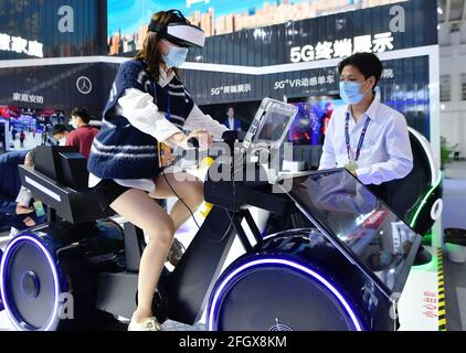 Fuzhou, Chinas Provinz Fujian. April 2021. Auf der Digital Achievements-Ausstellung während des vierten Digital China Summit in Fuzhou, südöstlich der Provinz Fujian, am 25. April 2021, testet ein Besucher eine VR-Spinning auf Basis der 5G-Technologie. Quelle: Wei Peiquan/Xinhua/Alamy Live News Stockfoto