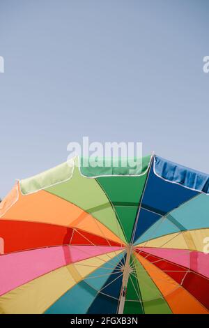 Offener, heller Sonnenschirm in blauem Himmel Stockfoto