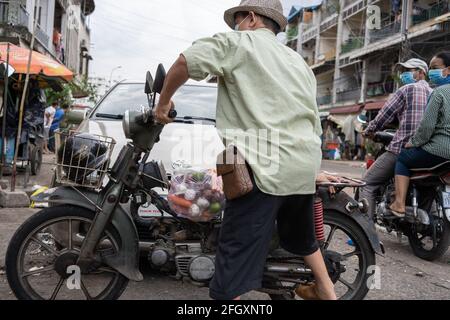 Phnom Penh, Kambodscha. April 2021. Während der Coronavirus-Pandemie lädt ein Mann sein Fahrrad mit gespendeten Lebensmitteln auf dem Deum Kor Markt.Phnom Penh bleibt in der Sperre, da Kambodscha drastische Maßnahmen ergreift, um die Ausbreitung des bisher schlimmsten COVID-19-Ausbruchs zu reduzieren. Die Sperre hat viele von ihnen aus der Arbeit gezwungen, darunter Fabrikarbeiter und Marktverkäufer, was die ärmsten Bewohner der Städte in Schwierigkeiten gebracht hat oder nicht in der Lage ist, sich grundlegende Notwendigkeiten zu leisten. (Foto von Andy Ball/SOPA Images/Sipa USA) Quelle: SIPA USA/Alamy Live News Stockfoto