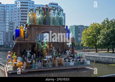 Sammlung von klassischen klaren Gefäßen in Blau-, Grün- und Brauntönen auf dem Regal eines Vintage-Straßenverkäufers in der Nähe der Honey Bridge über dem Pregolya-Fluss Stockfoto