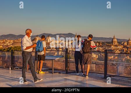 Die Menschen genießen den Blick auf die Stadt vom Aussichtspunkt auf der obersten Terrasse der Engelsburg bei Sonnenuntergang in Rom, Italien Stockfoto