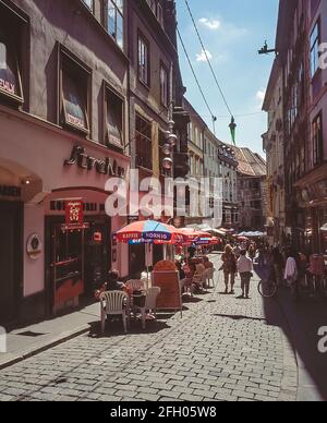 Bunte Straßenszene mit Al Fresco-Straßencafés in der Stadt Graz, Österreichs zweitgrößter Stadt im Bundesland Steiermark im Südosten Österreichs, unweit der Grenze zu Slowenien. Stockfoto