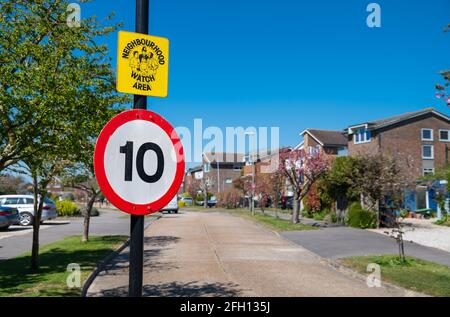 GESCHWINDIGKEITSBEGRENZUNGSSCHILD mit EINER GESCHWINDIGKEIT VON 10 KM/H und Neighborhood Watch Area-Schild am Eingang zu einer Wohnstraße oder Straße in England, Großbritannien. Stockfoto