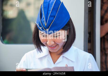 Almaty, Kasachstan - 06. Juni 2012: Schnellzug Talgo-Tulpar. Junge asiatische Zugwirtin in Garisson-Mütze. Überprüfen von Tickets. Stockfoto