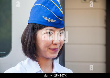 Almaty, Kasachstan - 06. Juni 2012: Porträt einer jungen asiatischen Zugwirtin in Garisson-Mütze. Talgo-Tulpar-Schnellzug. Stockfoto