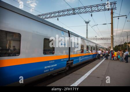 Almaty, Kasachstan - 06. Juni 2012: Schnellzug Talgo-Tulpar auf dem Bahnsteig des Bahnhofs. Passagiere rechts. Stockfoto