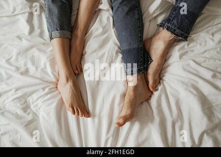 Nahaufnahme der Beine eines jungen Paares in schlecht getragen Jeans Stockfoto