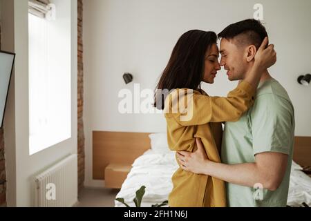 Glückliches junges Paar umarmt sich und zeigt ihre Gefühle. Junge Familie zieht in eine neue Wohnung Stockfoto