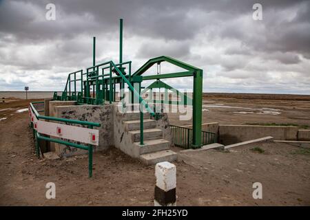 Aklak-Staudamm am Fluss Shardara. Kleiner manueller Wasserverschluss. Grauer, wolkig. Kasachstan, Region Kzylorda. Stockfoto