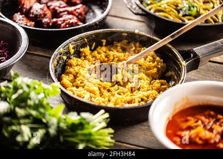 Italienisches cremiges Risotto mit Safran, Kurkuma oder Butternut in einer Pfanne mit einem Holzlöffel. Stockfoto