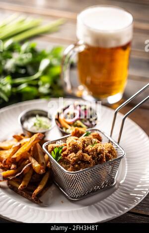 Gebratene Chicken Nuggets mit pommes Frites, Dip, Salat und Bier. Stockfoto