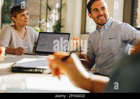 Team teilt kreative Ideen für ein neues Projekt. Mann, der in einer Gruppendiskussion sitzt und nach neuen Vorschlägen von Mitarbeitern fragt. Stockfoto