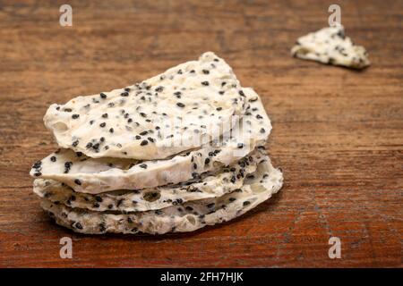 Scheiben (Chips) von getrockneten weißen Drachenfrüchten gegen rustikale Verwitterung Holz Stockfoto