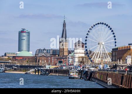 Blick auf den Rheindamm, die Ergo-Versicherung, den Schlosssturm und historische Gebäude mit Riesenrad in Düsseldorf Stockfoto