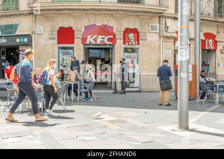 Palma de Mallorca, Spanien; april 23 2021: Hauptfassade des Franchise-Restaurants Kentucky Fried Chiken KFC an der Plaza de España. Bürger mit Gesicht m Stockfoto