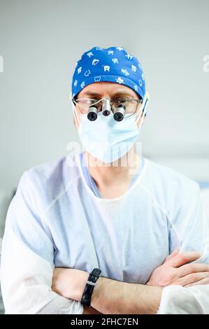 Männlicher Arzt in Uniform und sterile Maske Blick auf die Kamera Stockfoto