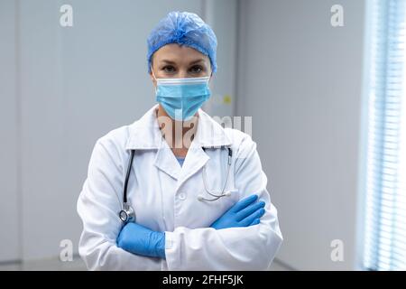 Porträt einer kaukasischen Ärztin mit Maske und Latexhandschuhen Stockfoto