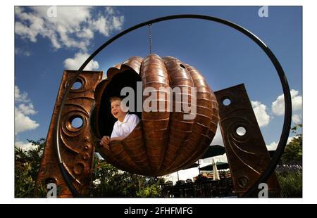 Letzte min Vorbereitung bei der Hampton Court Palace Flower Show.......öffentlich zugänglich 6-11 Juli 2004.pic David Sandison 5/7/2004 der junge Jonathan Burns genießt einen Giant Pumpkin Swing von Fletcher & myburgh bei der Hampton Court Palace Flower Show......öffentlich zugänglich 6-11 Juli 2004. Pic David Sandison 5/7/2004 Stockfoto