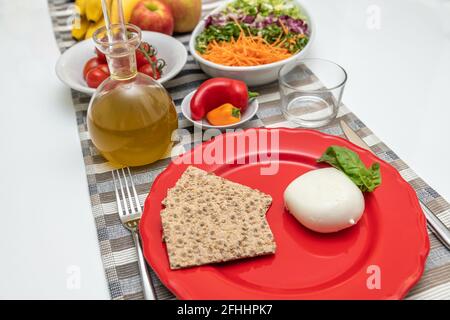 Nahrhafte Gerichte, zubereitet mit Mozzarella-Salat und Tomaten. Natürliche und gesunde Zutaten der mediterranen Ernährung: Olivenöl, Getreide, Paprika, Stockfoto