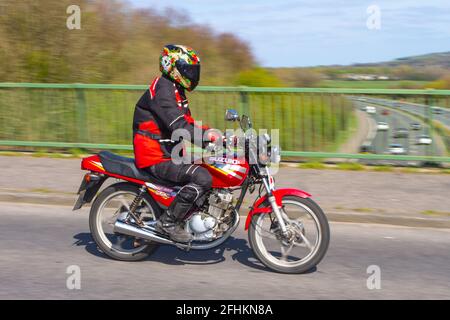 2000 rot 124 ccm Suzuki Motorradfahrer; zweirädrige Transport, Motorräder, Fahrzeug auf britischen Straßen, Motorräder, Motorradfahrer fahren in Manchester, Großbritannien Stockfoto