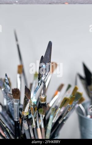 Legen Sie die Pinsel für die Kunst der Sammlung in der Tasse auf dem Desktop des Künstlers fest. Künstlerische Ausrüstung Im Studio Stockfoto
