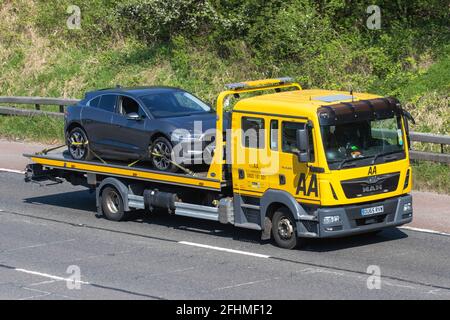 AA Pannendienst am Straßenrand 24 Stunden Pannendienst; Autotransporter man Lieferwagen, Mitführen von defekten Autotransporten, Rettungs-LKW am Straßenrand, Fracht, Fahrzeug, Lieferung, Gewerbliche Transportindustrie, auf der M61 in Manchester, Großbritannien Stockfoto