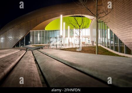 Calgary Alberta Kanada, April 22 2021: Moderne Architektur und leere Parkbänke bei Nacht am Eingang des Royal Oak YMCA. Stockfoto