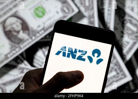 China. April 2021. In dieser Abbildung sehen Sie das Australia and New Zealand Banking Group Limited, das gemeinhin als ANZ-Logo bezeichnet wird, das auf einem Smartphone mit US-Dollar (USD) im Hintergrund angezeigt wird. Kredit: Budrul Chukrut/SOPA Images/ZUMA Wire/Alamy Live Nachrichten Stockfoto