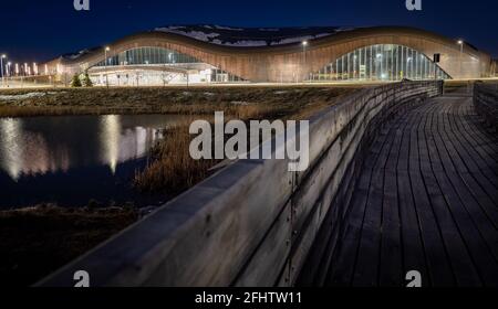 Calgary Alberta Kanada, April 22 2021: Moderne Architektur der Royal Oak YMCA entlang einer Holzpromenade über einen natürlichen Teich am Abend. Stockfoto
